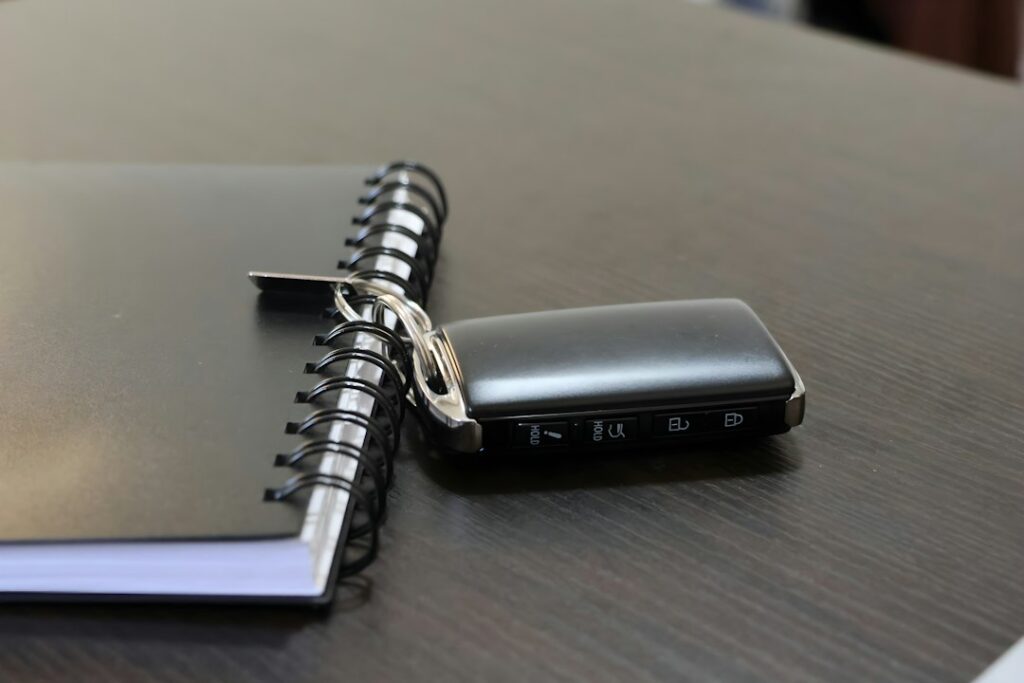 Car key beside a notebook on a desk, illustrating car quotation comparison